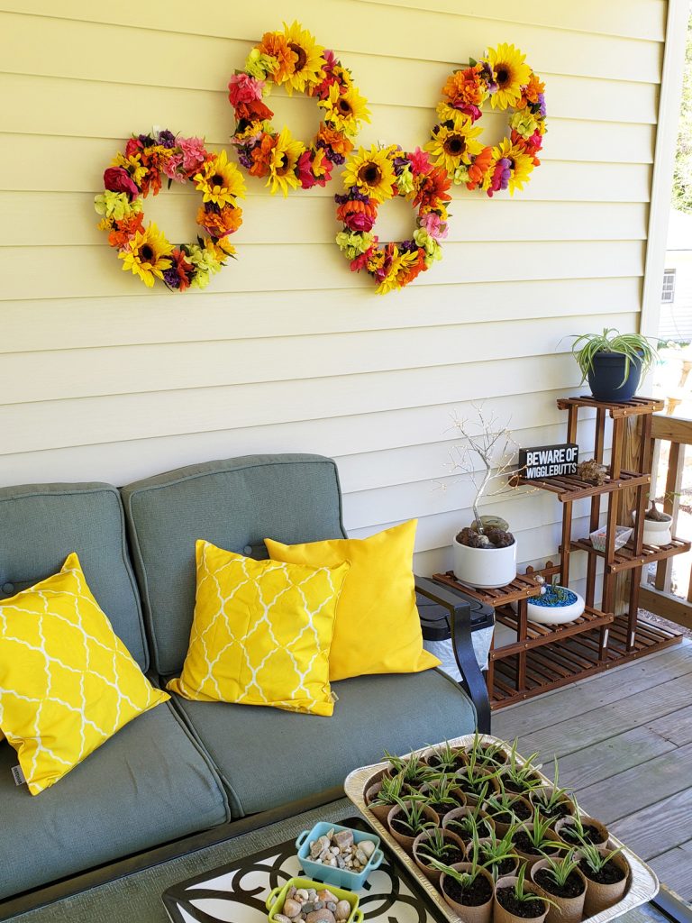 Arrangement of four colorful wreaths with sunflowers on an outdoor wall of porch.