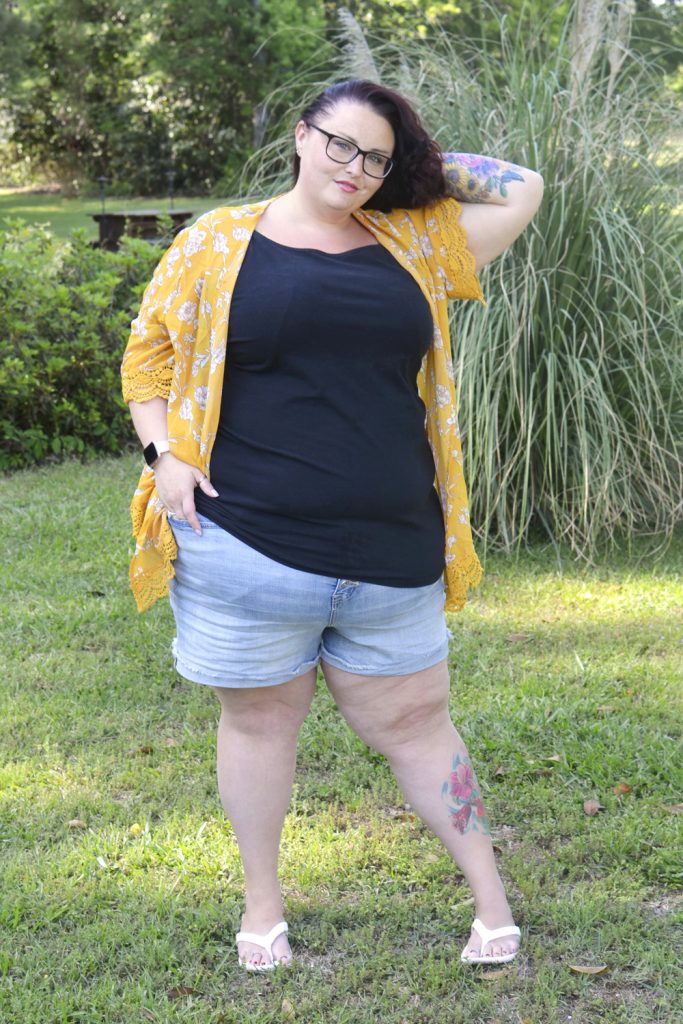 Plus size woman outside wearing Torrid shorts, tank top and kimono for OOTD.