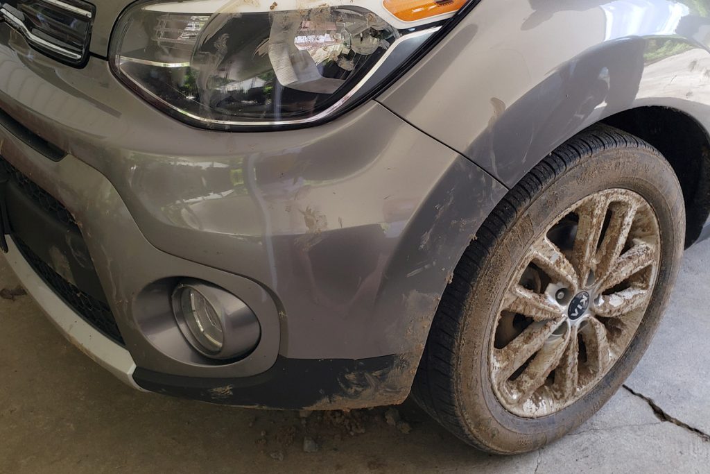 Front driver's side view of very muddy Kia Soul.