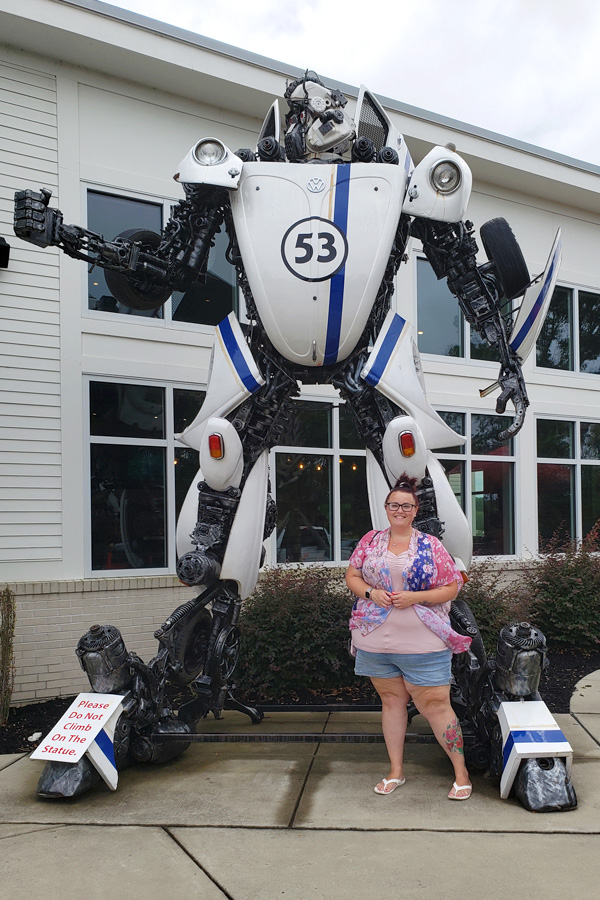 Maranda stands with a giant Transformer-style robot statue made from Volkswagen parts outside Mellow Mushroom in Murrells Inlet, SC.