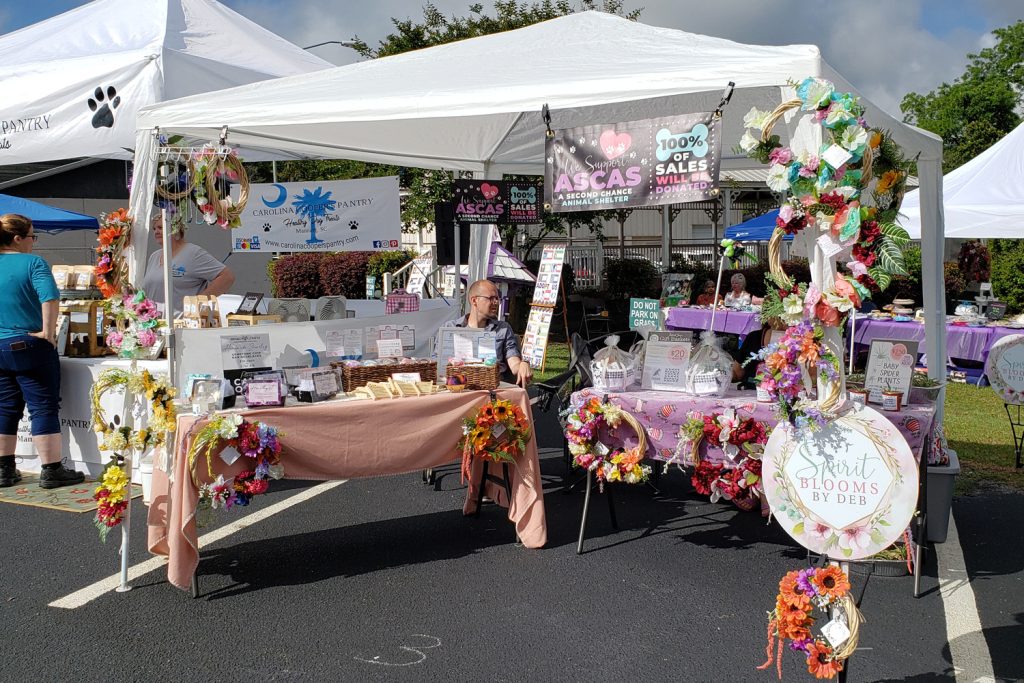 White tent set up at an outdoor craft show featuring shared space between Awaken Gemini and Spirit Blooms by Deb.