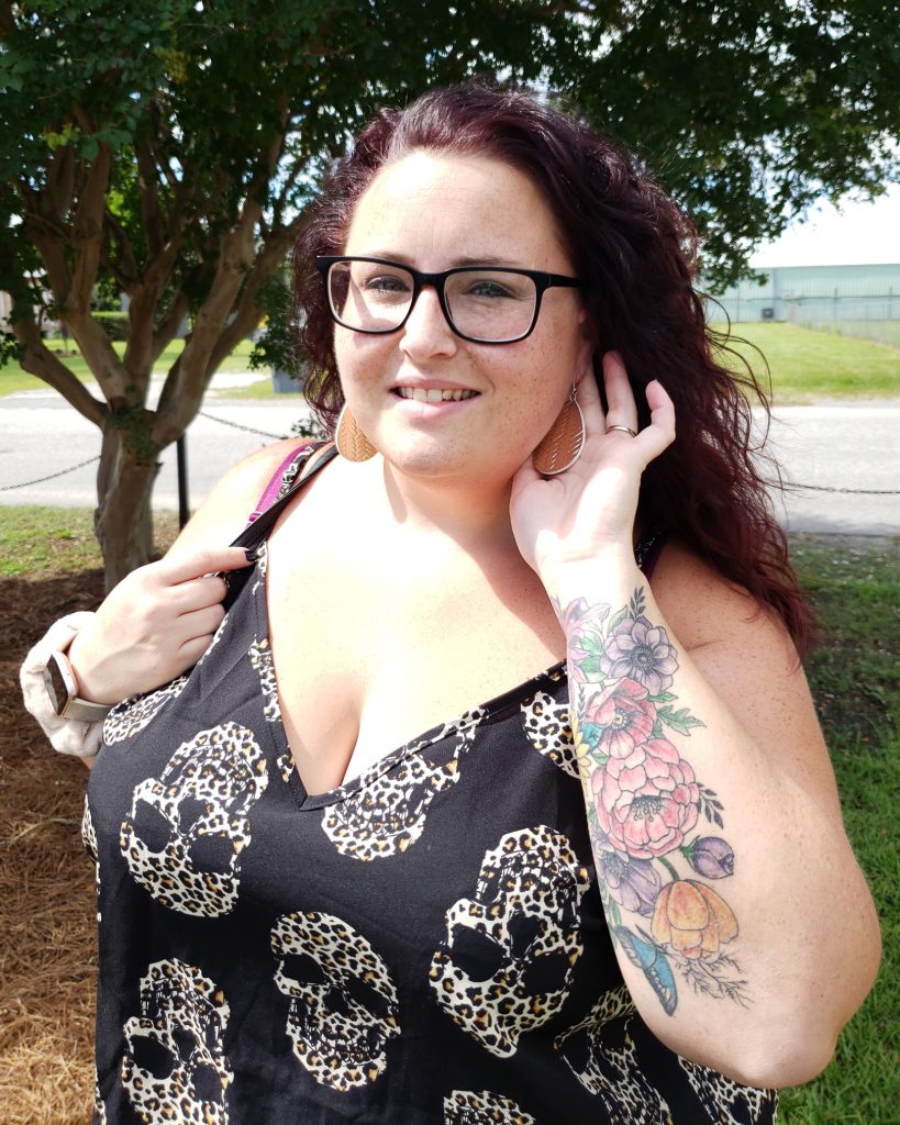 Maranda, a plus size woman, models shiny metallic gold water drop earrings from Shein paired with a black skull print cami top.