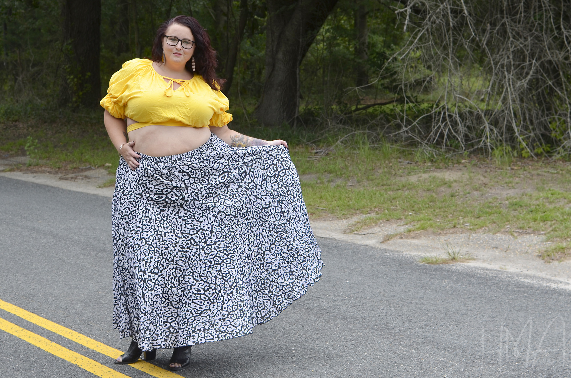 Maranda, a plus size woman, models a Jessica London maxi skirt with leopard print standing in the roadway.