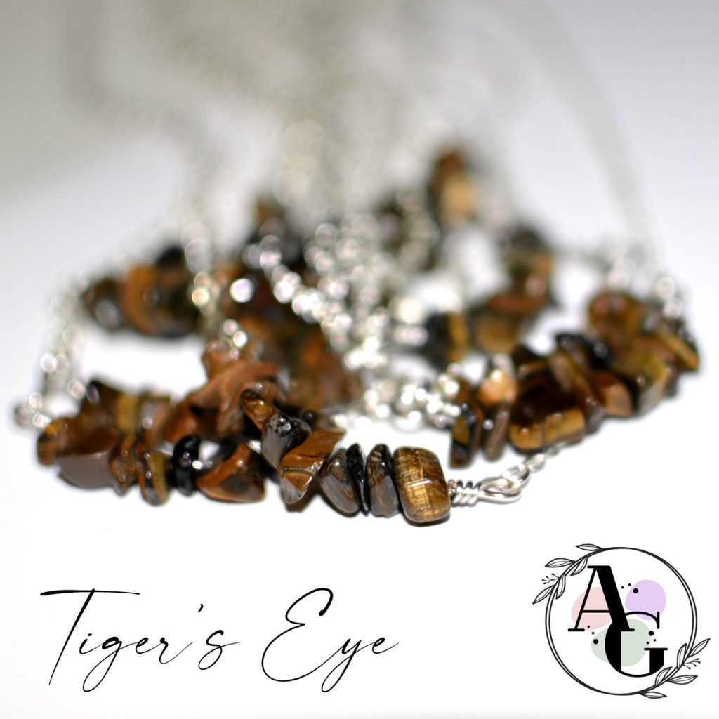 Tiger's eye gemstone chip beads on bar necklaces, shining on white background.
