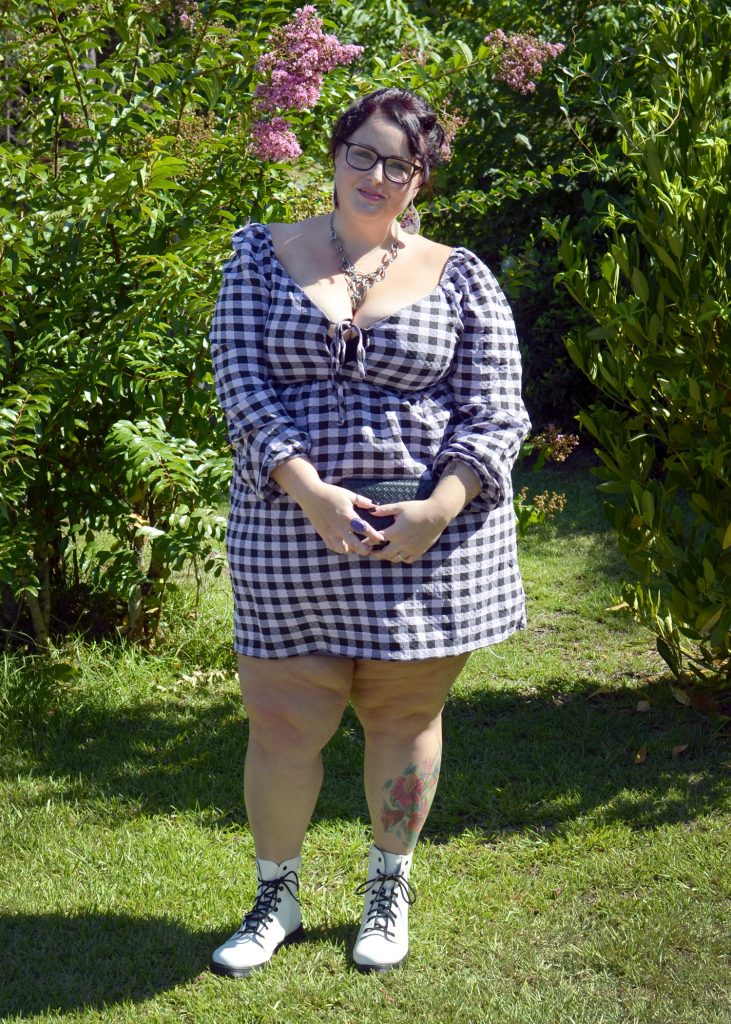 Maranda, a plus size woman, models a purple and black gingham muse dress from Wild Fable brand with white combat boots.