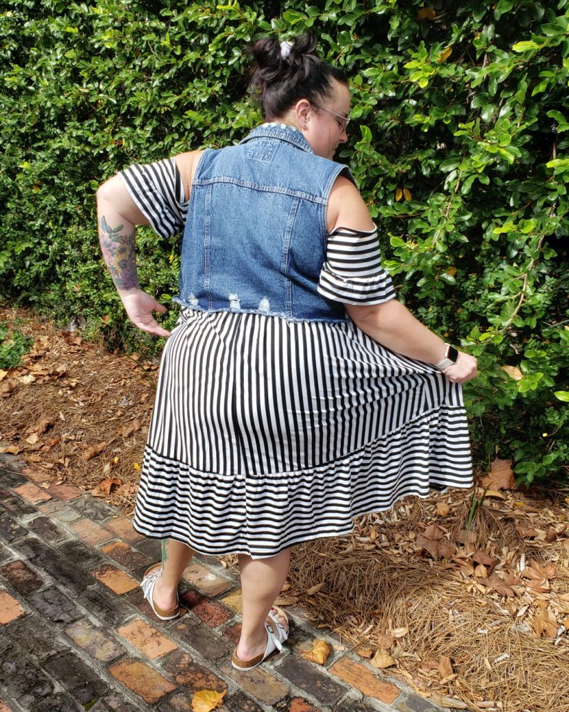 Plus size Maranda models a Shein cold-shoulder ruffle striped dress from the back, holding the midi-length skirt out to the side.