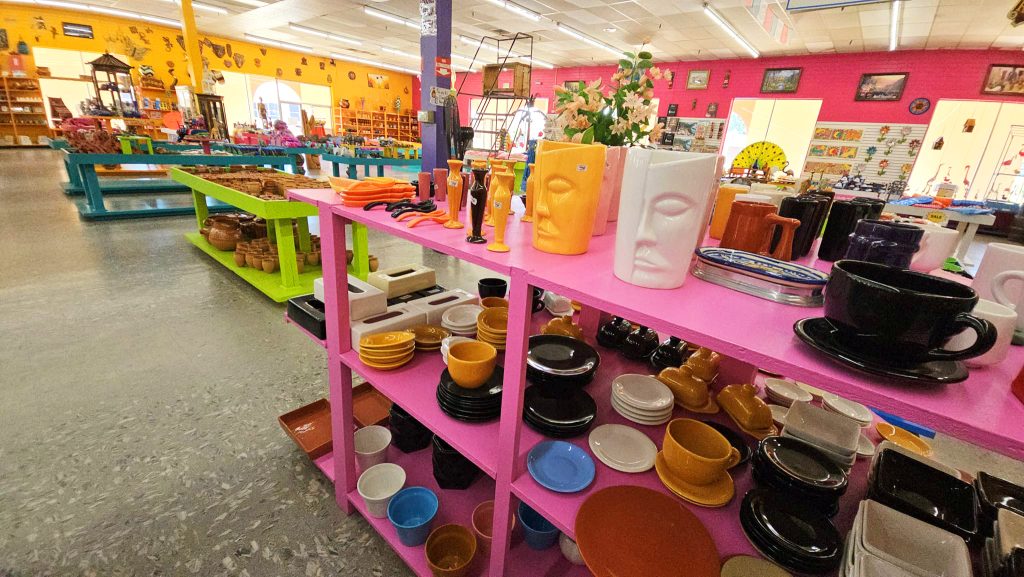 Colorful indoor shot looking toward the back of the Mexico Shop East gift store at South of the Border attraction. Pottery, dishware, and kitsch home decor items in various colors and styles.
