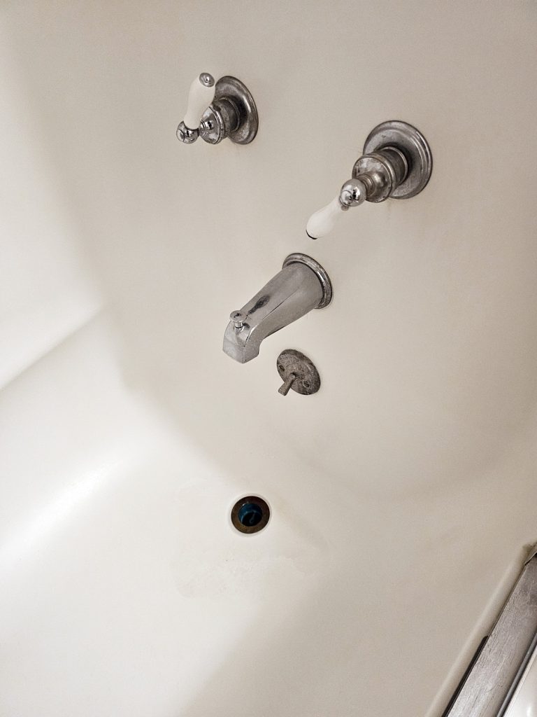 Bathtub faucet, drain, and hardware - very clean - at South of the Border Motor Inn guestroom.